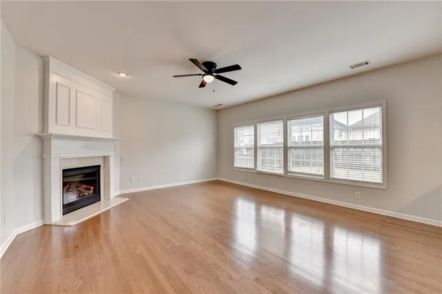 a view of an empty room with a fireplace and a window
