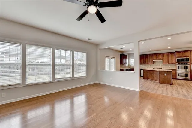 a kitchen with stainless steel appliances kitchen island granite countertop wooden floors and a sink