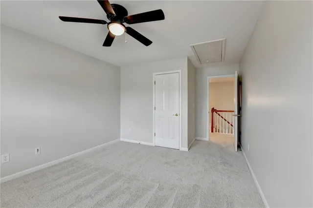 an empty room with a ceiling fan and window