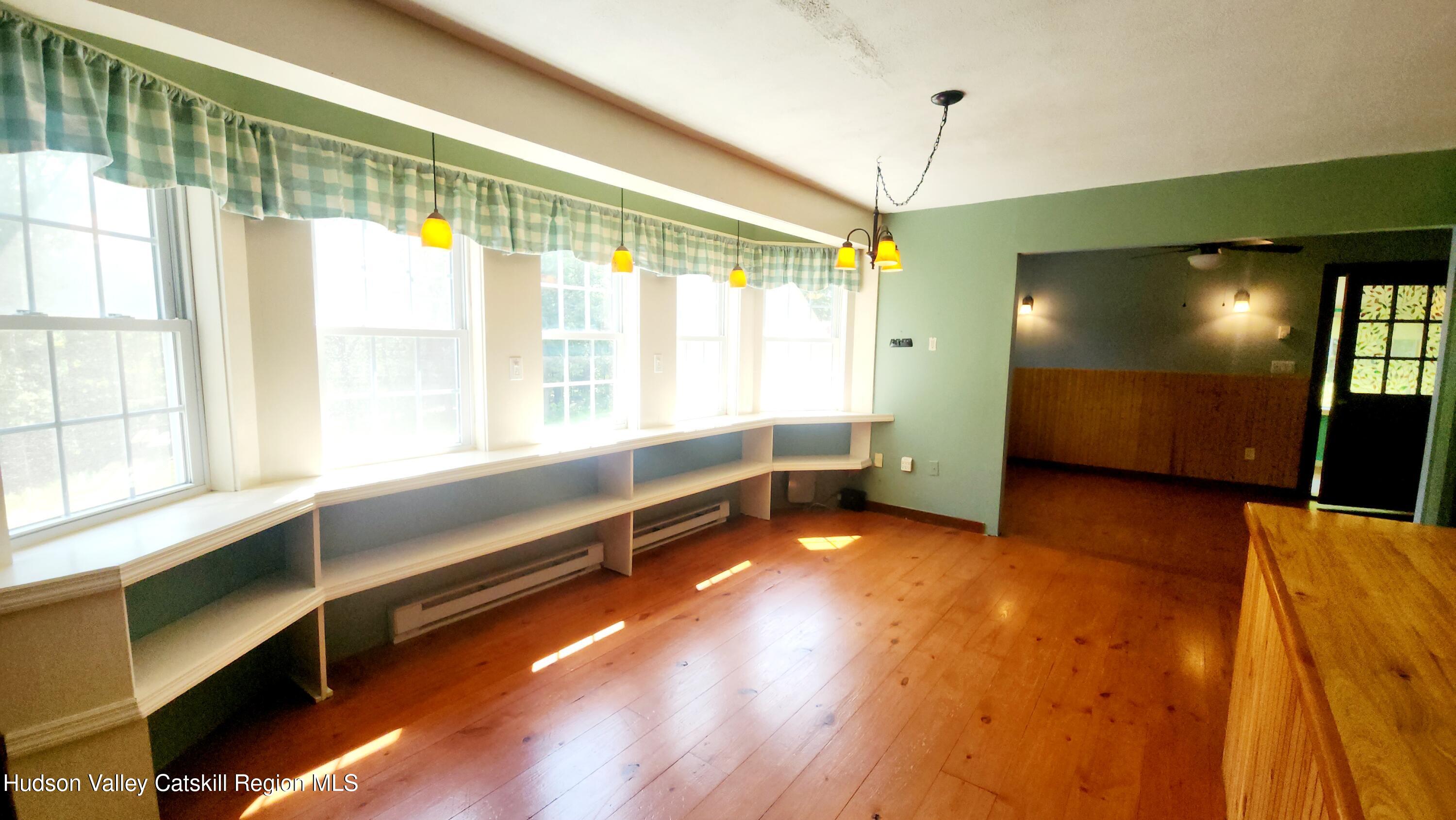 783 Broome Center Road Preston Hollow, NY 12469 - Photo 10 of 34 a view of an empty room with windows and a chandelier