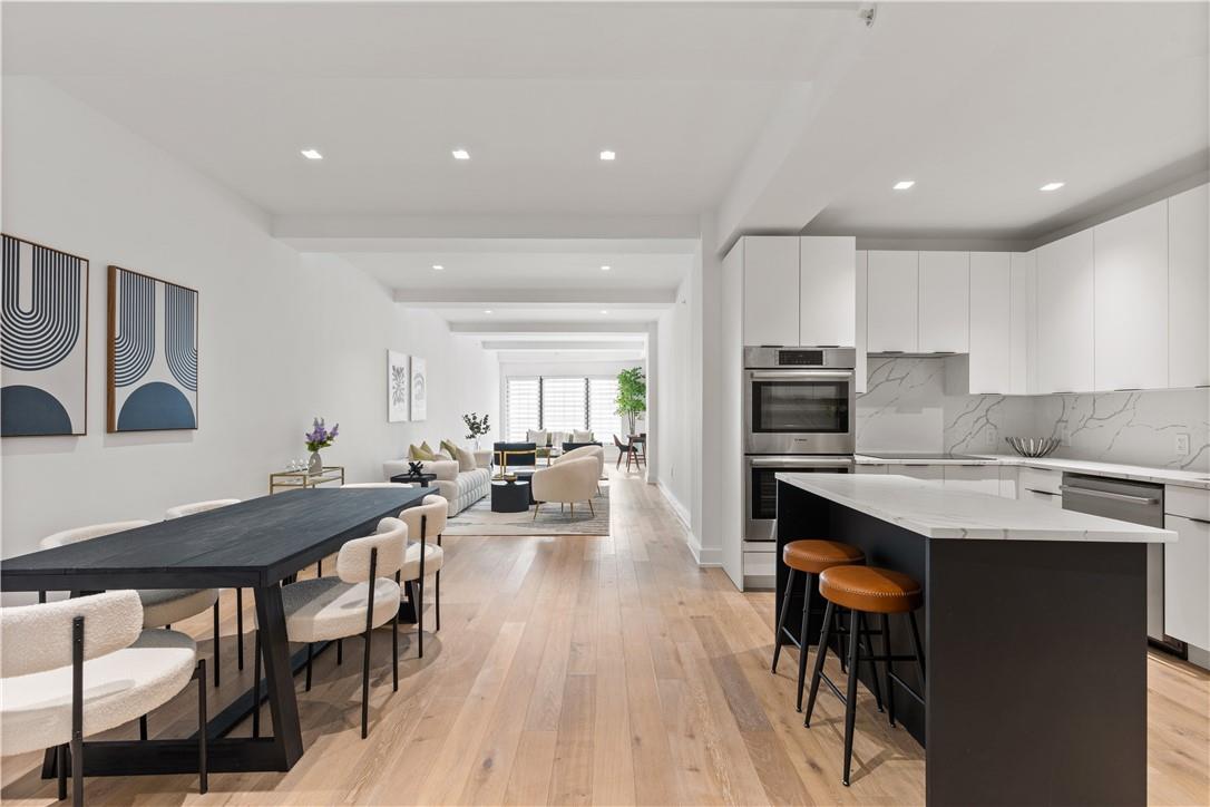 a kitchen with stainless steel appliances a table chairs refrigerator and cabinets
