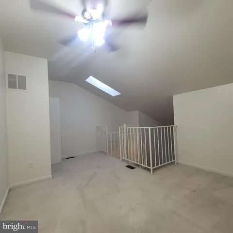 an empty room with a ceiling fan and window