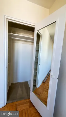 a view of walk in closet with empty racks