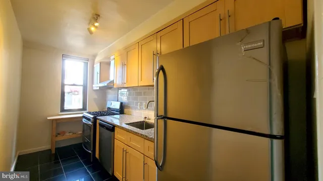 a kitchen with granite countertop a sink a counter top space and cabinets