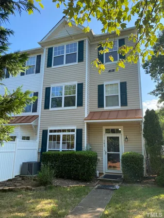 a front view of a house with a yard and a fountain