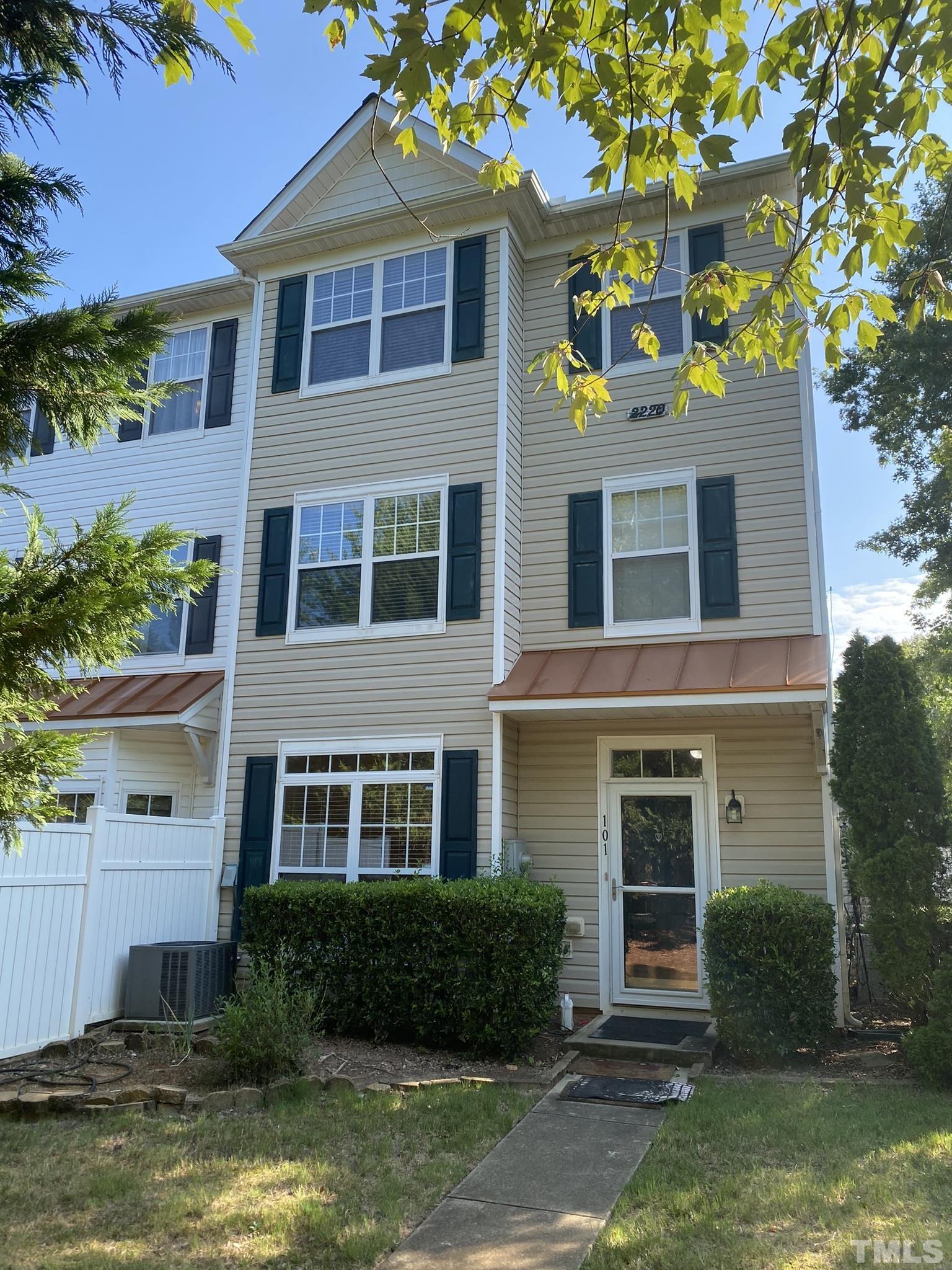 a front view of a house with a yard and a fountain
