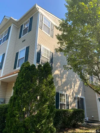 a front view of a house with plants and trees