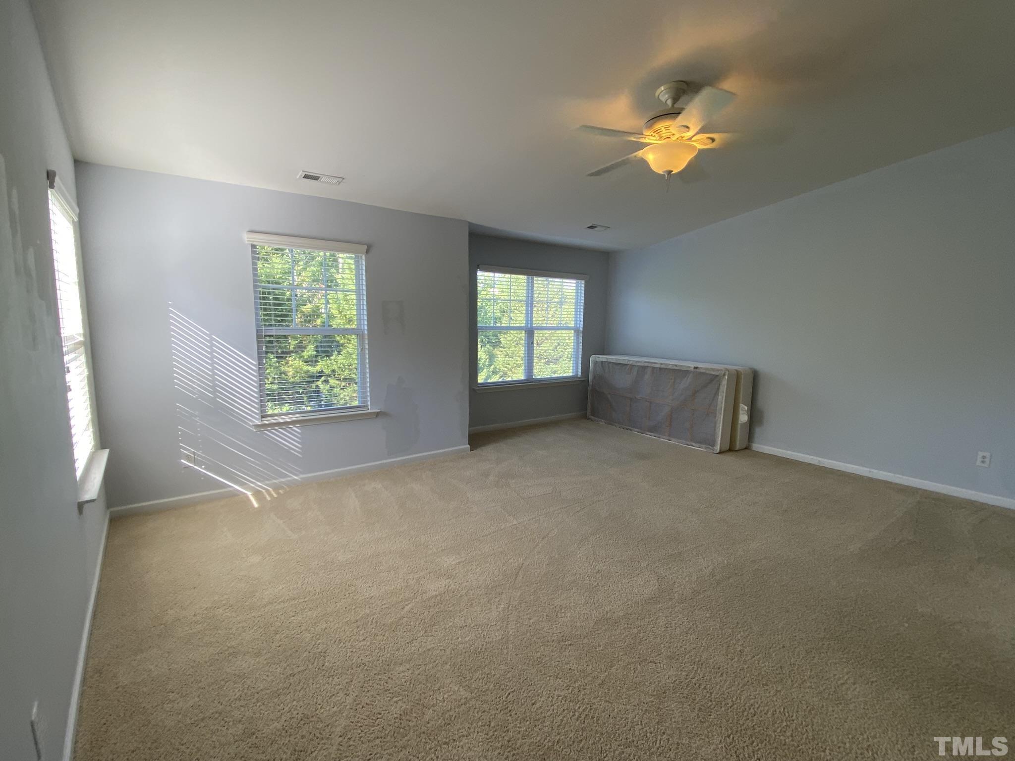 2220 Raven Road, Unit 101 Raleigh, NC 27614 - Photo 22 of 26 an empty room with windows and ceiling fan