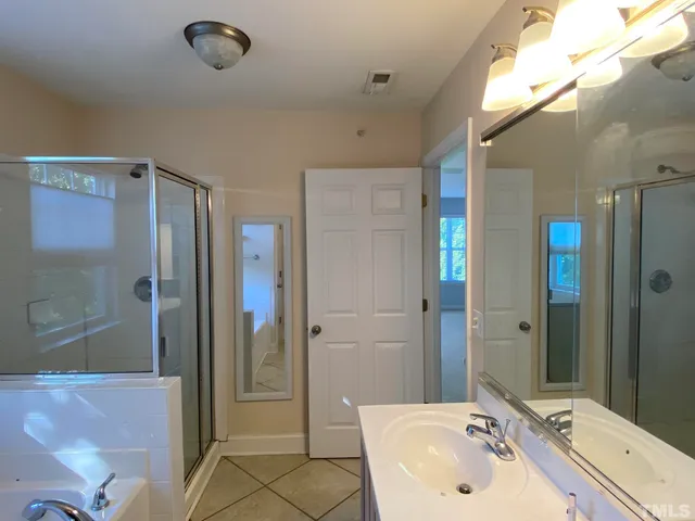 a bathroom with a sink mirror and shower