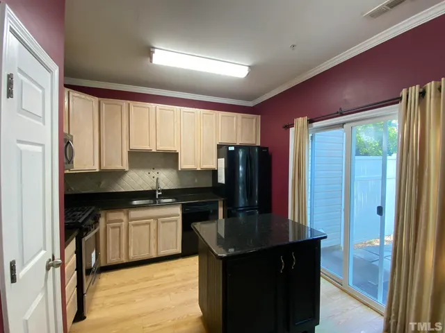 a kitchen with granite countertop a sink cabinets and stainless steel appliances