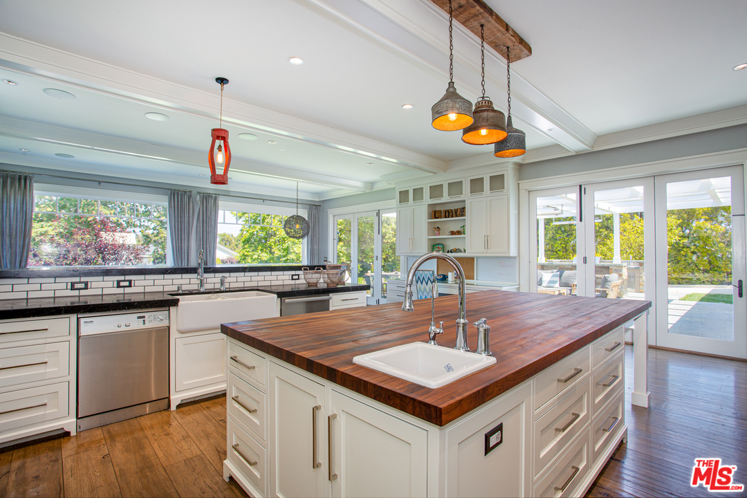 6692 Wildlife Road Malibu, CA 90265 - Photo 11 of 37 a kitchen with kitchen island granite countertop a stove a sink and wooden cabinets