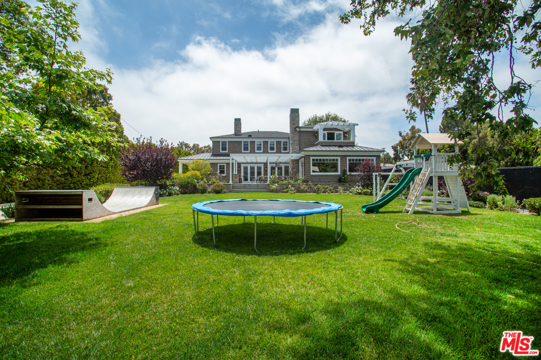 6692 Wildlife Road Malibu, CA 90265 - Photo 31 of 37 a view of a house with a swimming pool and a yard
