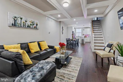 a living room with furniture and wooden floor