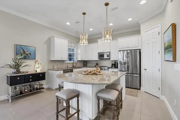 a kitchen with kitchen island granite countertop a sink and refrigerator