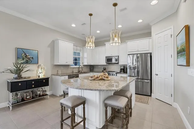 a kitchen with kitchen island granite countertop a sink and refrigerator