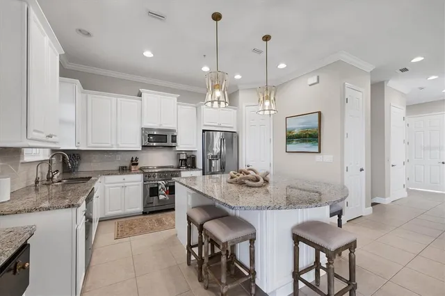 a kitchen with stainless steel appliances granite countertop a sink stove and cabinets