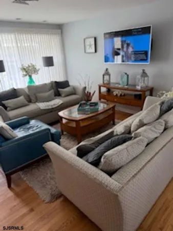 a living room with furniture and a wooden floor
