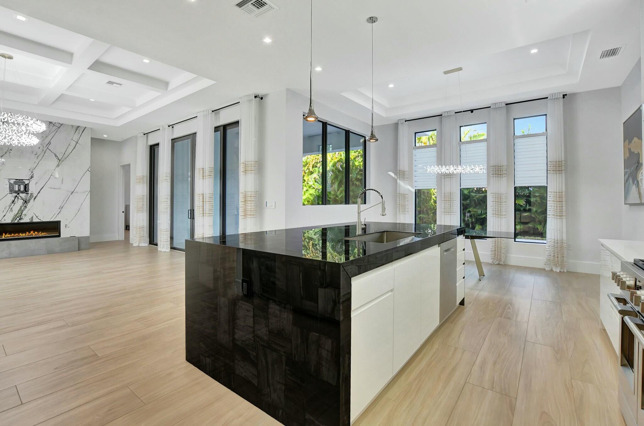 1470 Northeast 4th Avenue Boca Raton, FL 33432 - Photo 27 of 86 a large white kitchen with kitchen island granite countertop a large window and stainless steel appliances