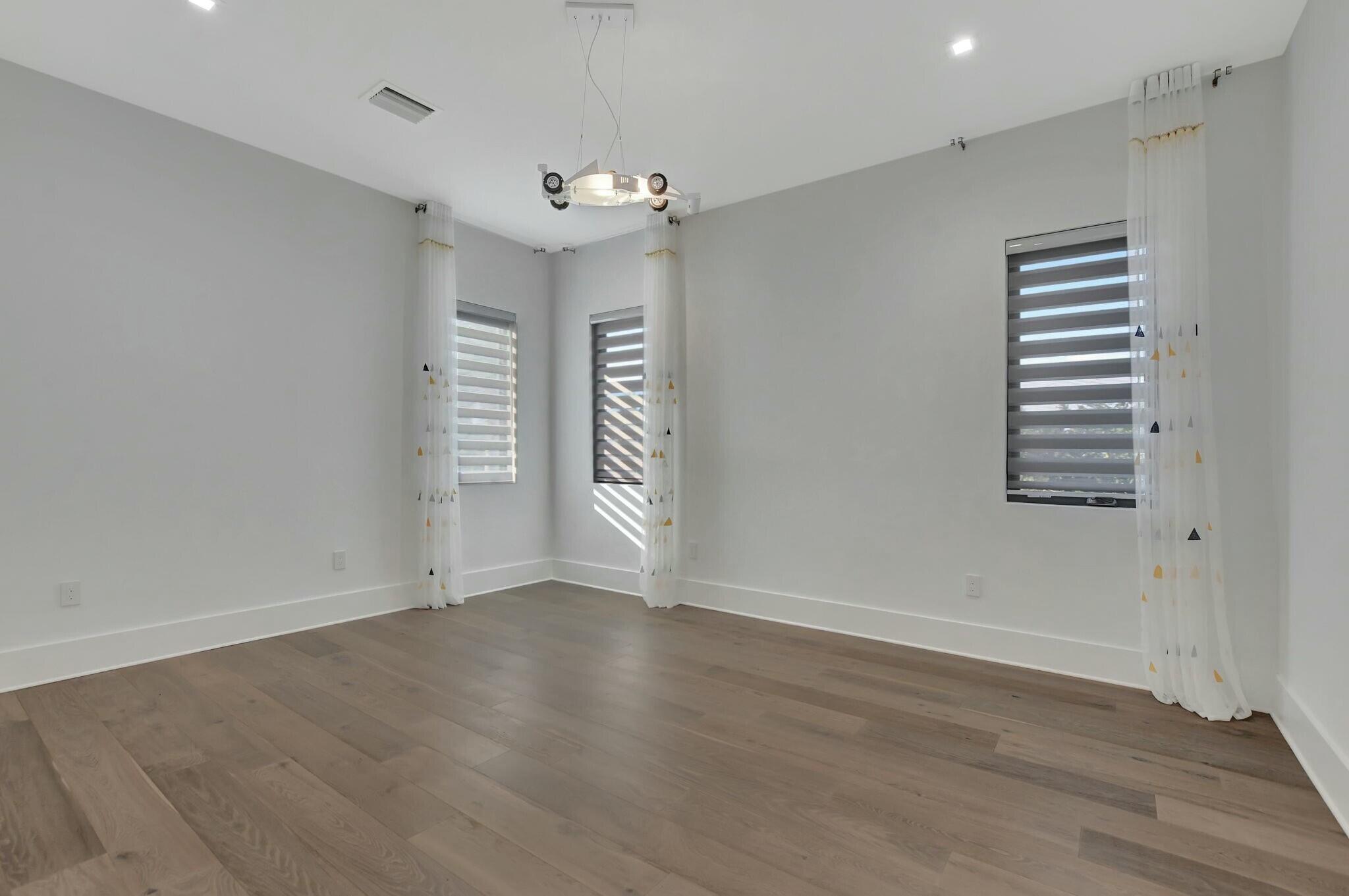 1470 Northeast 4th Avenue Boca Raton, FL 33432 - Photo 60 of 86 an empty room with wooden floor and windows