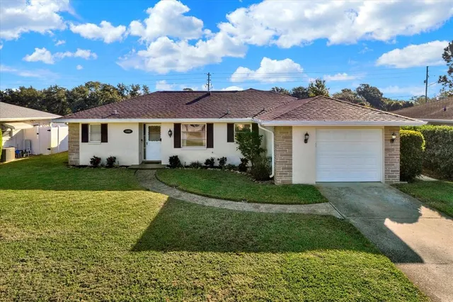 a view of a white house with a yard and plants