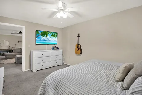 a bedroom with a bed and a flat tv screen on dresser
