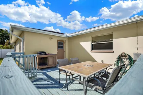 a balcony view with a dining table and chairs with wooden floor