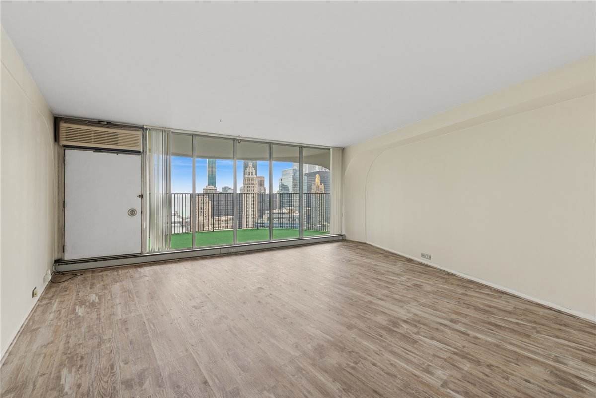 300 North State Street, Unit 4831 Chicago, IL 60654 - Photo 7 of 11 wooden floor in an empty room with a window