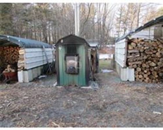 56 Birch Meadow Road Merrimac, MA 01860 - Photo 4 of 7 a view of a wooden house with a yard and garage