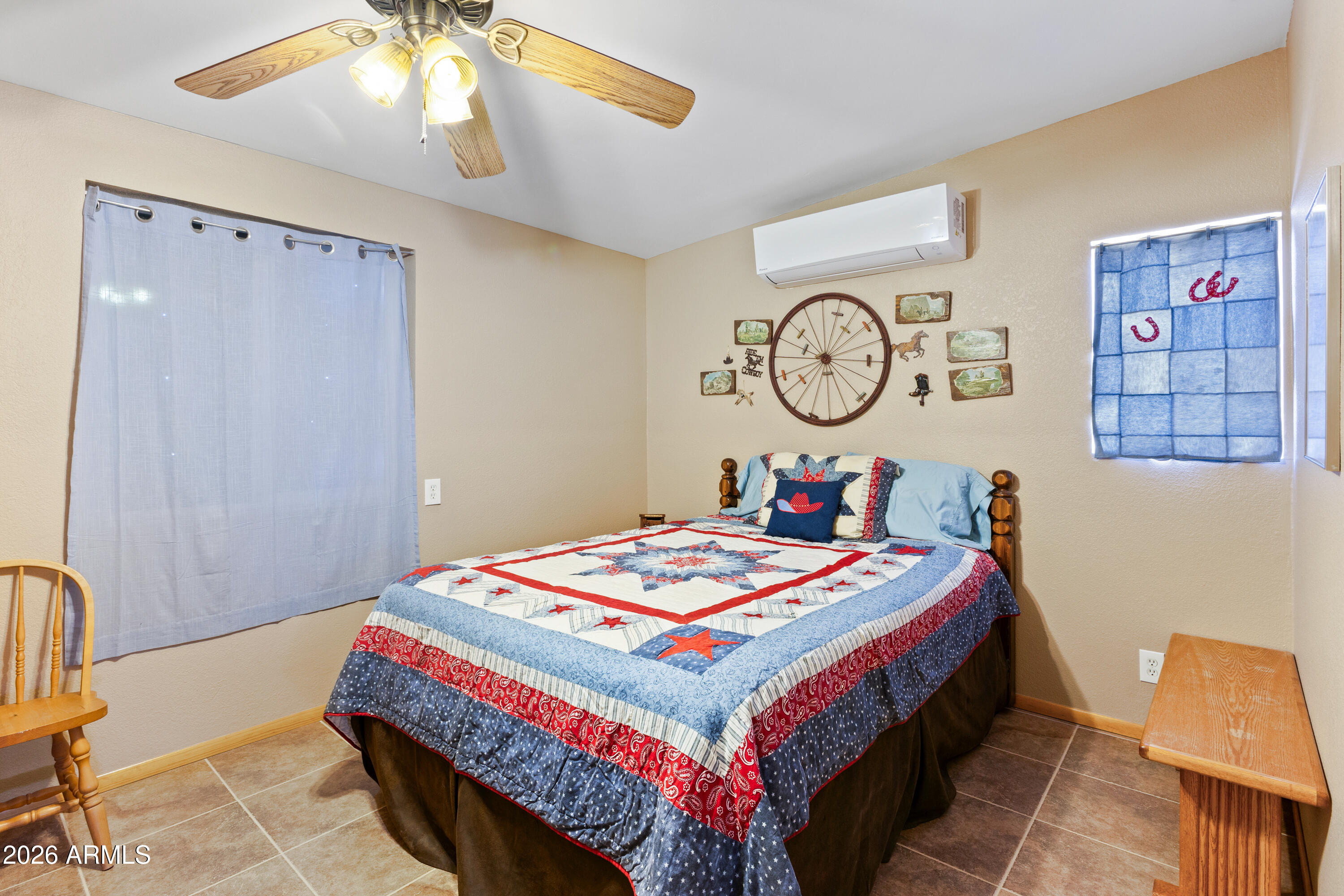 20526 West Carver Road Buckeye, AZ 85326 - Photo 29 of 43 a bedroom with a bed a chandelier and a dresser
