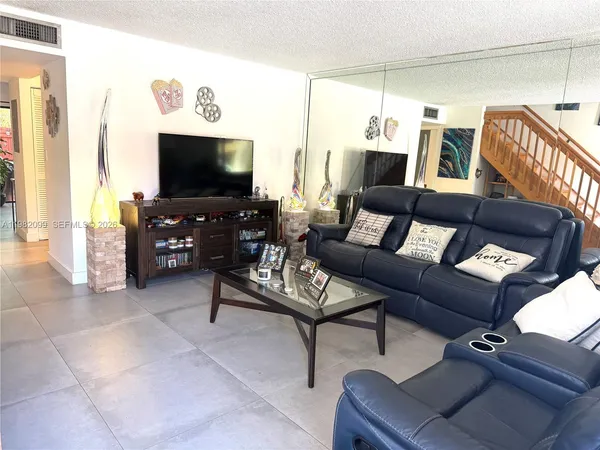 a dining room with furniture and a potted plant