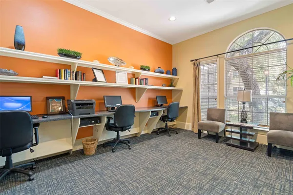a view of a workspace with furniture and a window