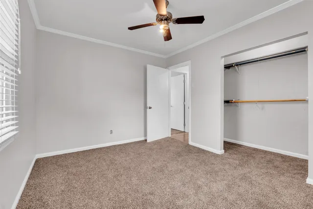 an empty room with a ceiling fan and a window