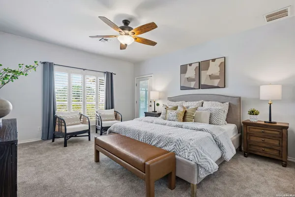 a bedroom with a bed a couch and a large window