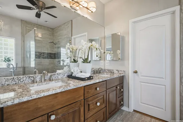 a bathroom with a granite countertop sink double vanity and mirror