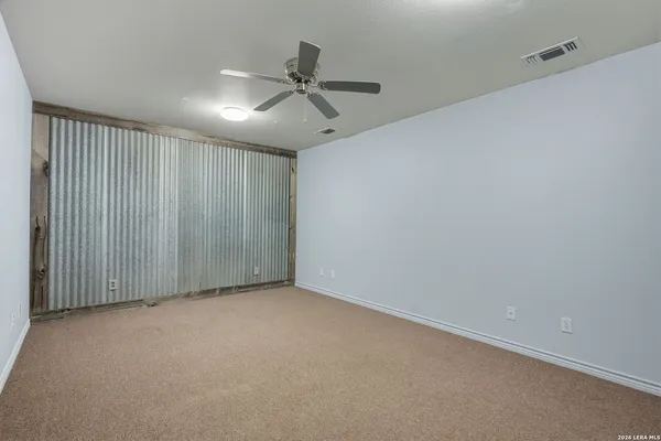 an empty room with a ceiling fan and carpet