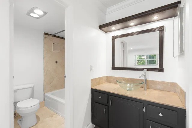 a bathroom with a toilet a sink a mirror and a shower