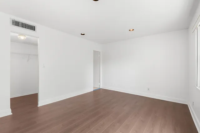 a view of an empty room with wooden floor