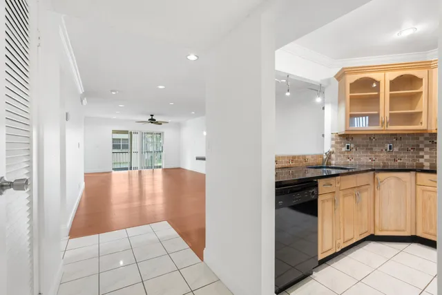 a view of a kitchen with granite countertop a sink and a stove top oven