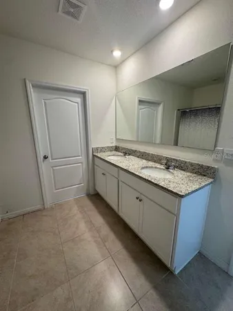 a bathroom with a granite countertop sink and a mirror