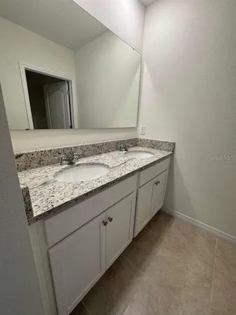 a bathroom with a granite countertop sink and a mirror