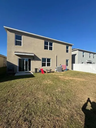 a view of a house with backyard and sitting area
