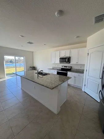a kitchen with stainless steel appliances granite countertop a sink and a stove