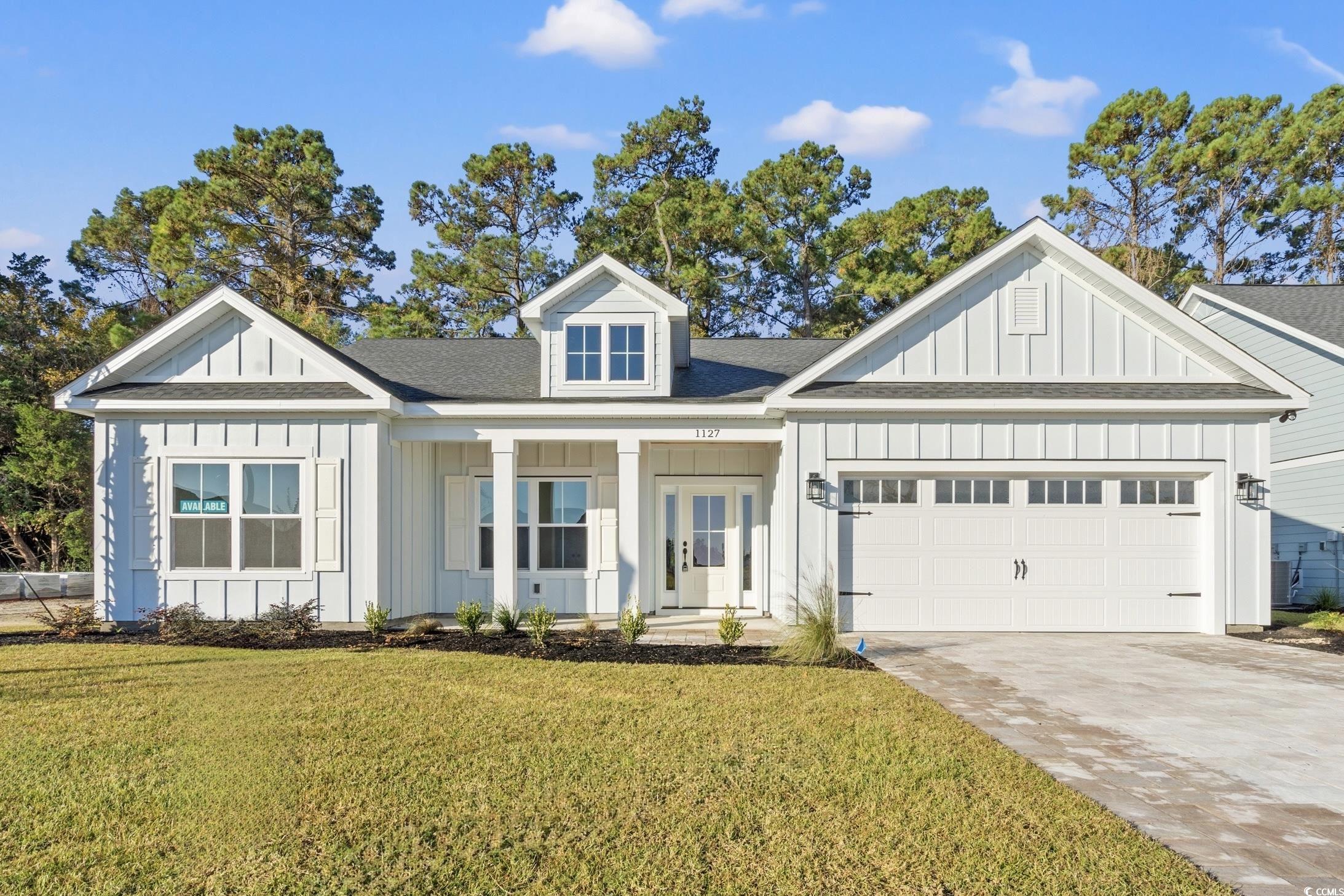 1127 Crooked Hook Road North Myrtle Beach, SC 29582 - Photo 1 of 32 Modern inspired farmhouse featuring board and batten siding, covered porch, driveway, a front lawn, and a shingled roof