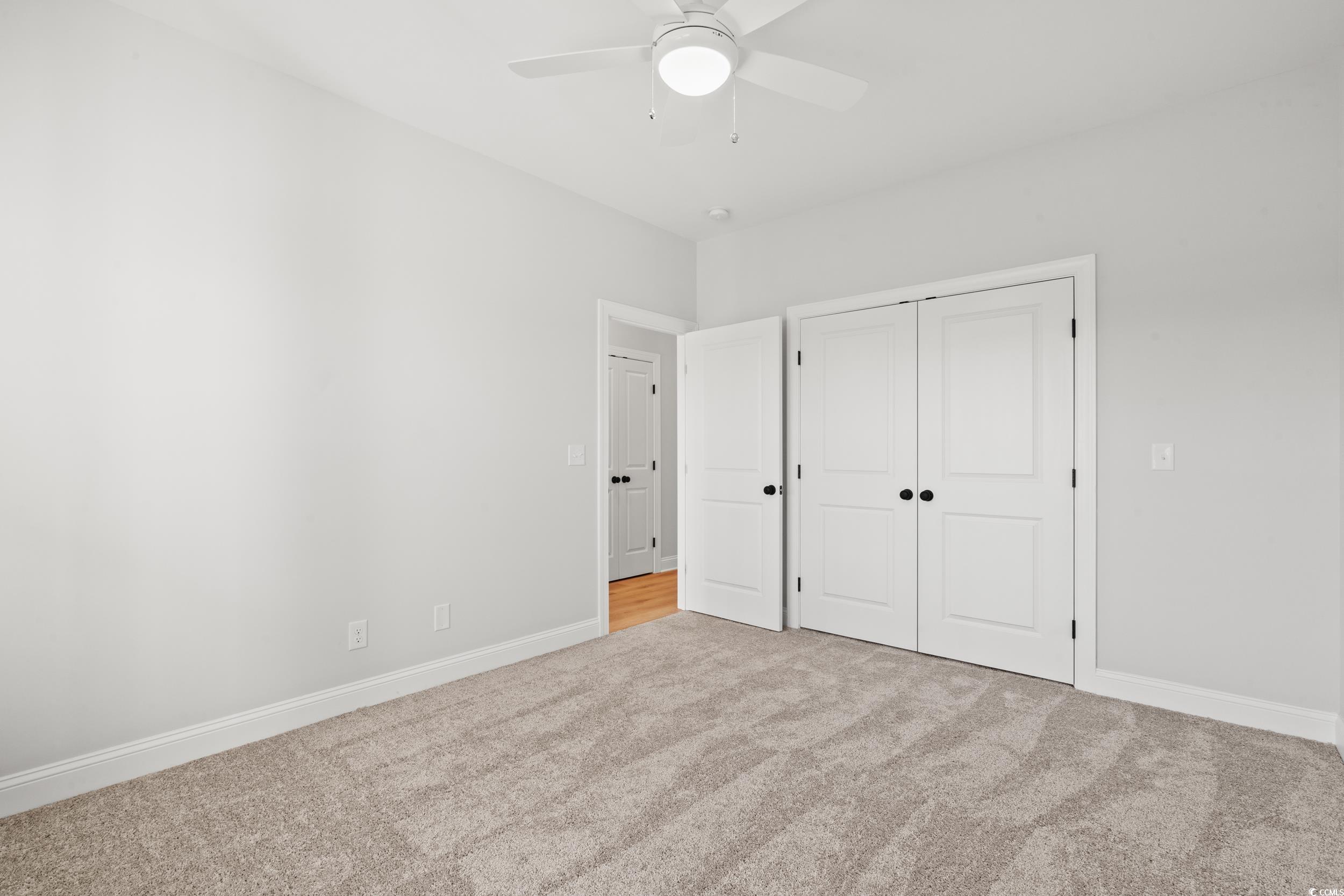 1127 Crooked Hook Road North Myrtle Beach, SC 29582 - Photo 11 of 32 Spare room with light carpet and ceiling fan