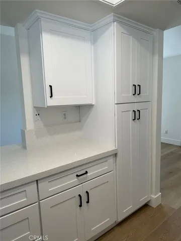 a view of a kitchen with white cabinets and a refrigerator