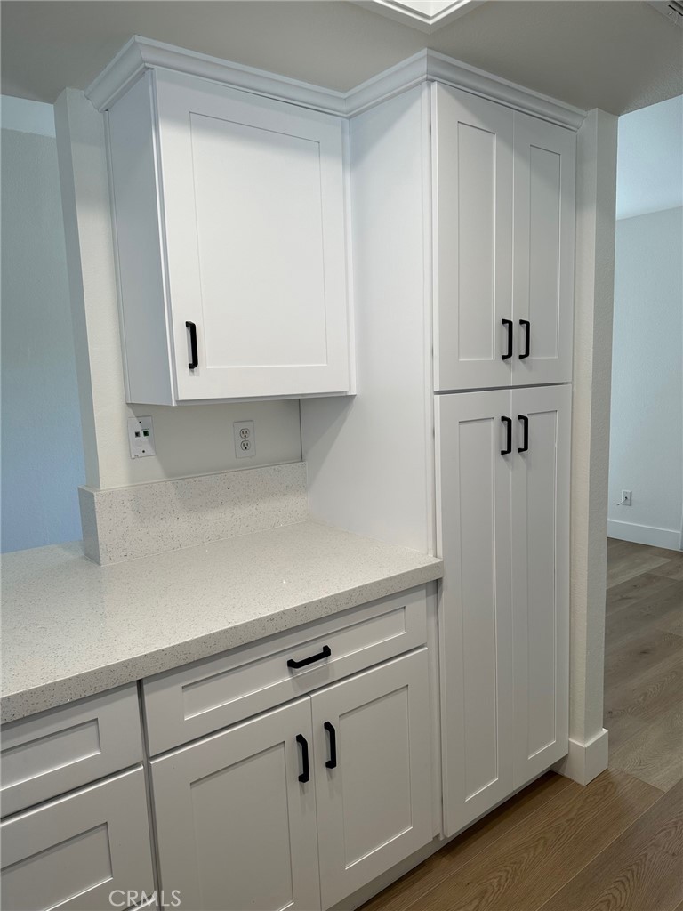 28142 Mariposa, Unit 154 Laguna Niguel, CA 92677 - Photo 11 of 35 a view of a kitchen with white cabinets and a refrigerator