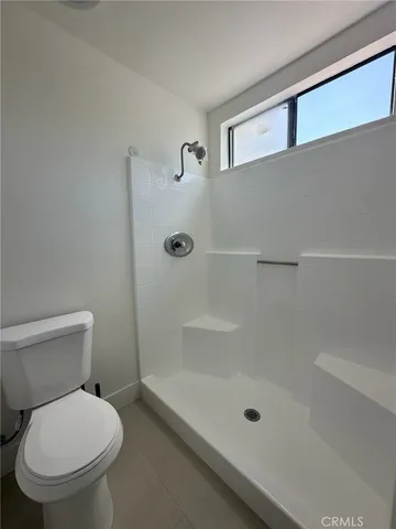 a bathroom with a toilet and a shower