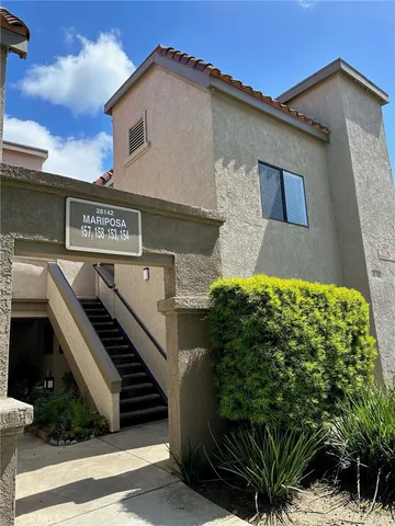 a front view of a house with garage and plants