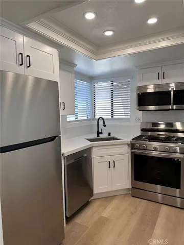 a kitchen with stainless steel appliances a refrigerator sink and microwave