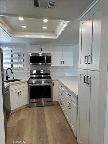 a kitchen with granite countertop a stove sink and cabinets